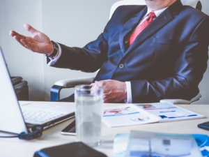 professional discussing performance over desk to avoid feedback leadership mistakes