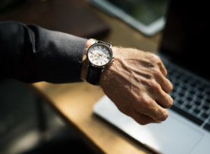 hand with watch over a laptop