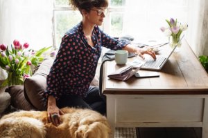 professional woman working on hr investments at home with dog