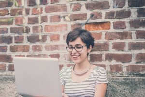 woman on laptop smiling after employee performance review