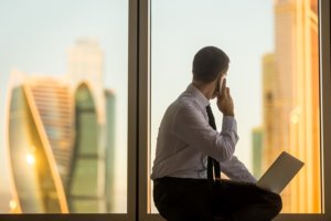 busy hr professional looking out window at city skyline