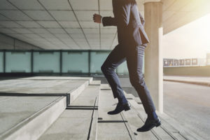 man in a suite running up stairs