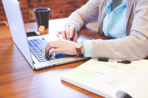 woman at wooden table with laptop