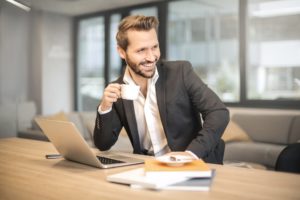 man at desk holding coffee