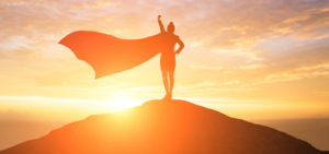 WOman standing on hill t sunset with superman cape